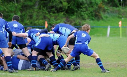 young rugby players in blue uniforms in a scrum